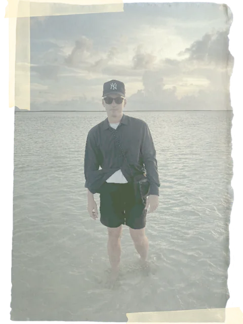Colin Cummins standing in shallow water at the beach
